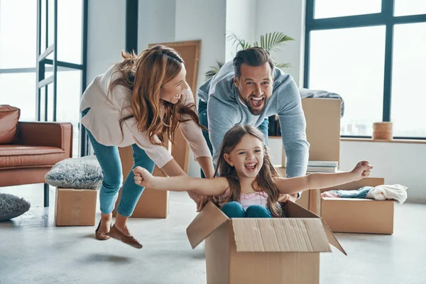 Οικογένεια χαμογελά και αποσυμπιέστε τα πράγματά τους, ενώ κινείται σε ένα νέο διαμέρισμα — Φωτογραφία Αρχείου