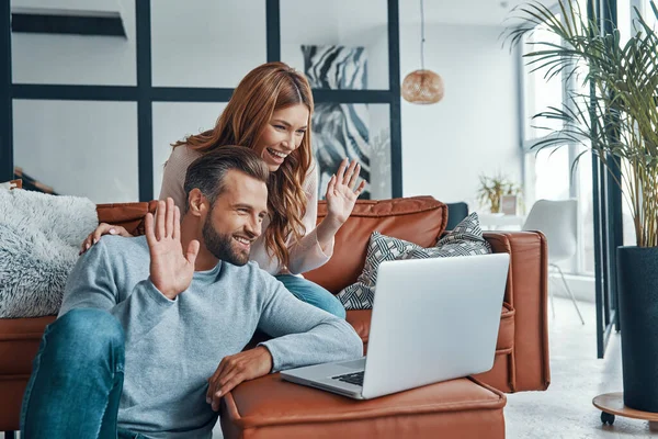 Amare la giovane coppia che fa una videochiamata con gli amici mentre trascorre del tempo a casa — Foto Stock