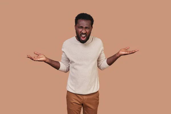 Frustrado joven africano en casual y haciendo gesto de enojo —  Fotos de Stock