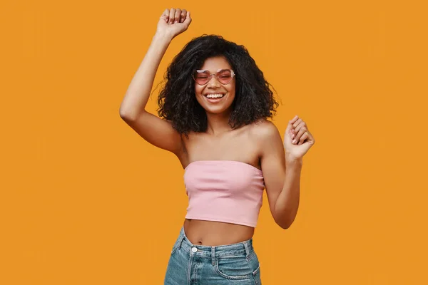 Hermosa joven africana en ropa casual bailando y sonriendo — Foto de Stock