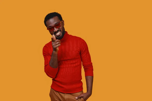 Guapo joven africano en ropa casual apuntando cámara y sonriendo — Foto de Stock