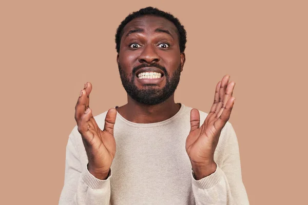 Retrato de un joven africano con ropa casual haciendo una cara y mirando a la cámara — Foto de Stock