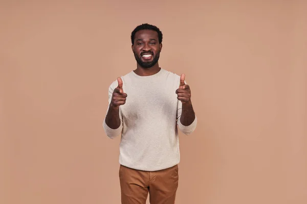 Knappe jonge Afrikaanse man in casual kleding kijken naar camera en glimlachen — Stockfoto