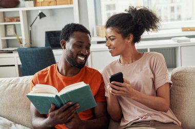 Güzel genç Afrikalı çift evde vakit geçirirken hobilerinin tadını çıkarıyor.