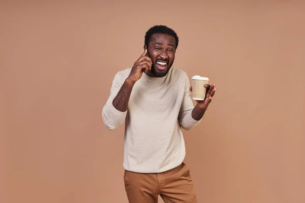 Bonito jovem africano em roupas casuais falando ao telefone e sorrindo — Fotografia de Stock