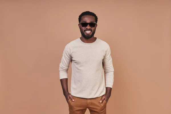 Stilig ung afrikansk man i glasögon ler och tittar på kameran — Stockfoto