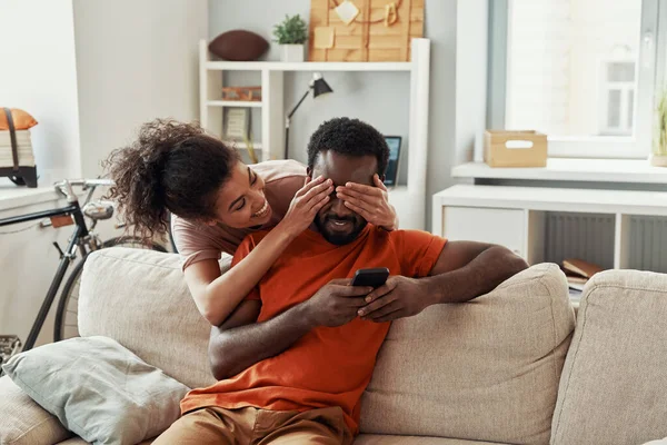Oyuncu genç Afrikalı kadın evde vakit geçirirken erkek arkadaşına göz kapatıyordu. — Stok fotoğraf