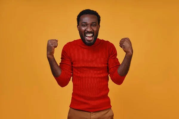 Jovem Africano alegre em roupas casuais gestos e olhando para a câmera — Fotografia de Stock