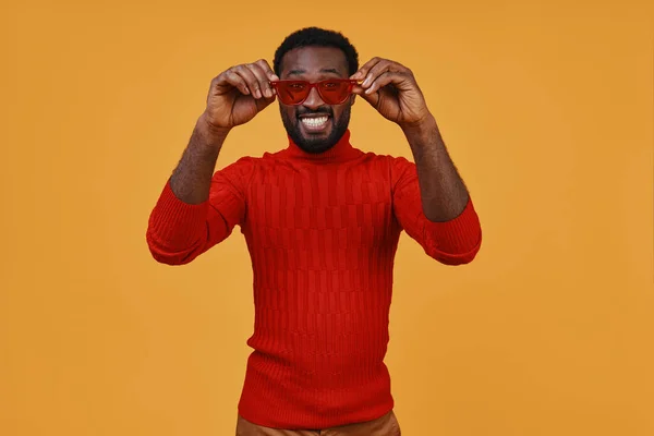 Handsome young African man in casual clothing looking at camera and adjusting eyeglasses — Stock Photo, Image