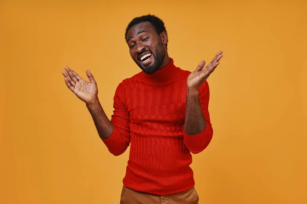 Bonito jovem africano em roupas casuais gesticulando e sorrindo — Fotografia de Stock