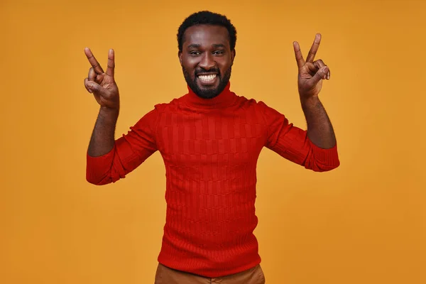 Bonito jovem africano em roupas casuais gesticulando e sorrindo — Fotografia de Stock