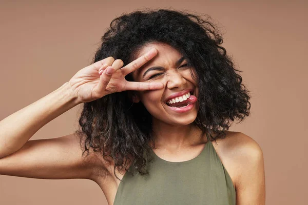 Beautiful young African woman in casual clothing smiling and gesturing — Stock Photo, Image