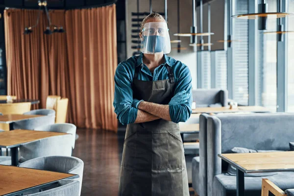 Confident male waiter in protective face shield keeping arms crossed — 스톡 사진