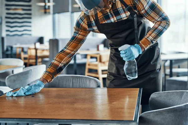 Close up of man in protective gloves cleaning table in restaurant — Stock Photo, Image