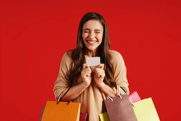 Весела молода жінка в повсякденному одязі з сумками і кредитною карткою — стокове фото