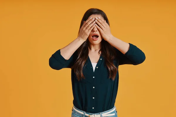 Shocked young woman in casual clothing covering eyes with hands — Foto Stock