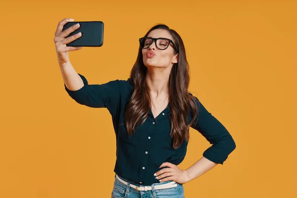 Happy young woman in casual clothing taking selfie and puckering — Stock Photo, Image