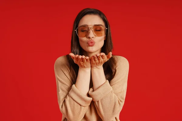 Attractive young woman in casual clothing blowing a kiss and smiling — ストック写真