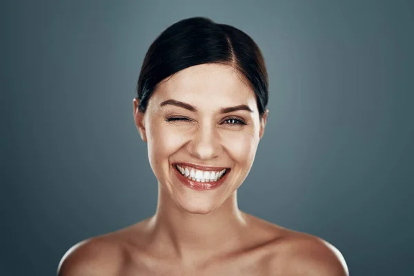 Belle jeune femme regardant la caméra et souriant tout en se tenant debout sur fond gris — Photo