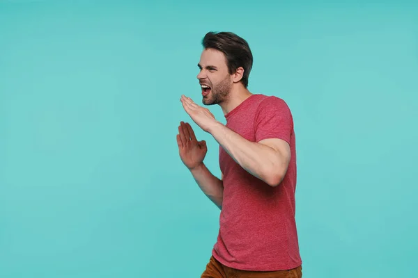 Schöner junger lächelnder Mann in lässiger Kleidung gestikuliert und lächelt — Stockfoto