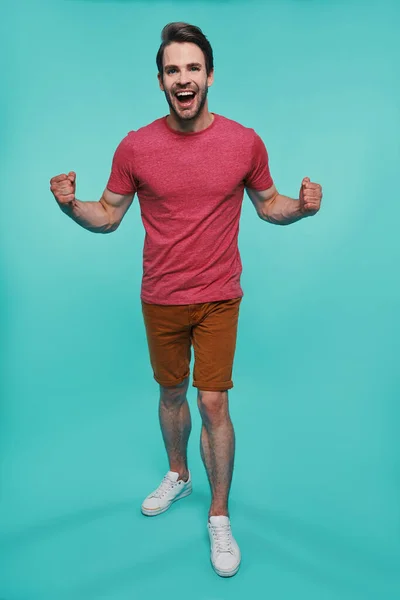 Full length of excited young man in casual clothing looking at camera and gesturing — Stock Photo, Image