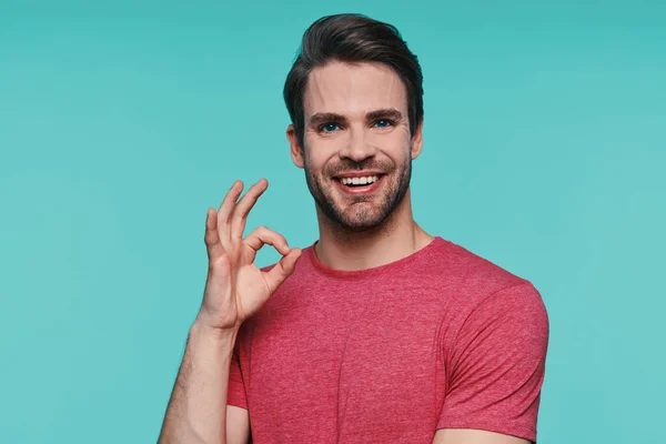 Guapo joven en ropa casual mirando a la cámara y el gesto — Foto de Stock