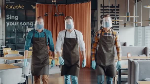 Mužští číšníci v ochranných pracovních oděvech se zkříženýma rukama a dívají se do kamery — Stock video