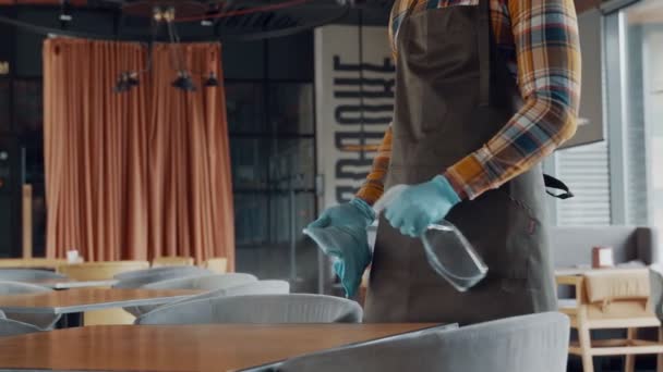 Detail muže v ochranných rukavicích čistící stůl v restauraci — Stock video