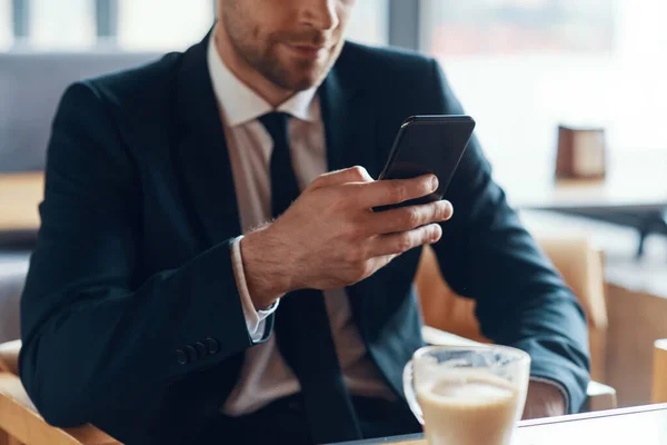 Close up of man in formalwear using smart phone while sitting in cafe — Stock Photo, Image