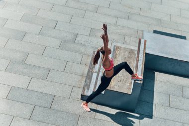 Kendine güvenen genç bir kadının spor giyim kuşamında açık havada egzersiz yaptığı en iyi manzara.