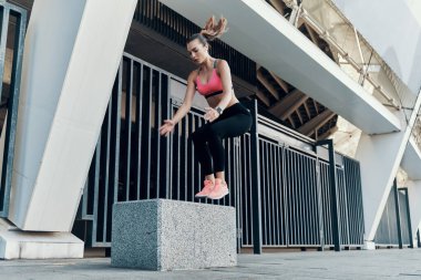 Spor elbiseli güzel bir kadın dışarıda sevişiyor.