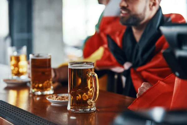 Großaufnahme glücklicher junger Männer mit internationalen Fahnen, die Bier genießen — Stockfoto