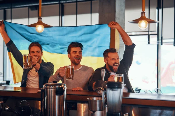 Drei jubelnde junge Männer mit ukrainischer Flagge und Bier — Stockfoto