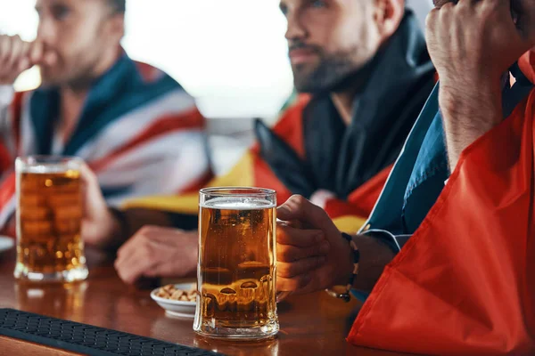 Nahaufnahme von jungen Männern mit internationalen Fahnen, die Bier genießen — Stockfoto