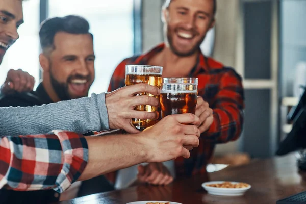 Gelukkig jonge mannen in casual kleding toosten elkaar met bier en glimlachen — Stockfoto