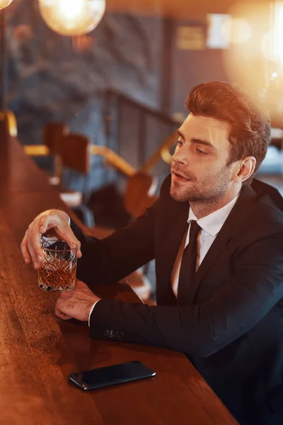 Κάτοψη του όμορφου νεαρού άνδρα με φουλ κοστούμι που πίνει αλκοόλ — Φωτογραφία Αρχείου