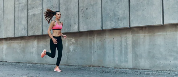 Mujer joven atractiva en ropa deportiva corriendo al aire libre —  Fotos de Stock