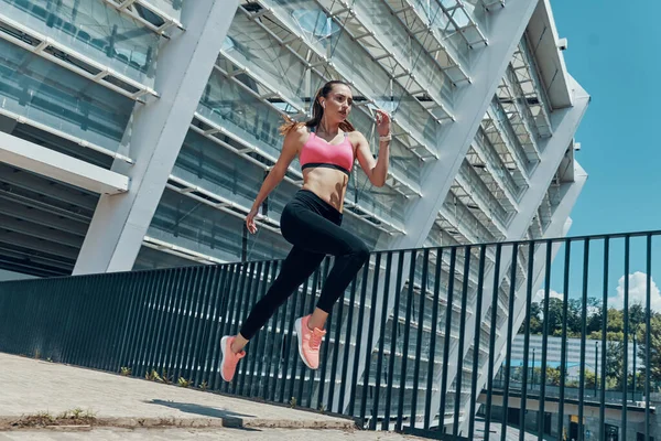 Schöne junge Frau in Sportkleidung läuft im Freien — Stockfoto