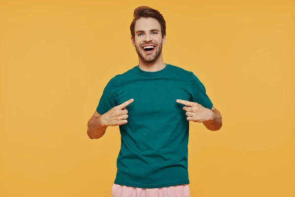 Handsome young smiling man in casual clothing looking at camera and pointing himself — Stock Photo, Image