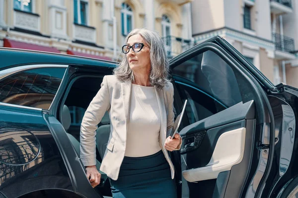Starší krásná žena v chytré ležérní oblečení při odchodu z auta venku — Stock fotografie