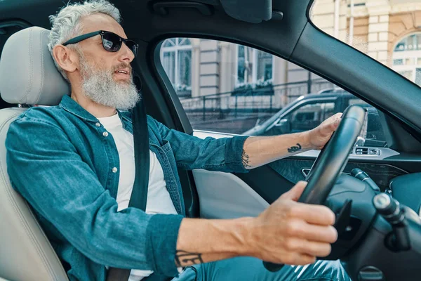 Selbstbewusster Senior in Freizeitkleidung genießt Autofahrt auf dem Beifahrersitz — Stockfoto