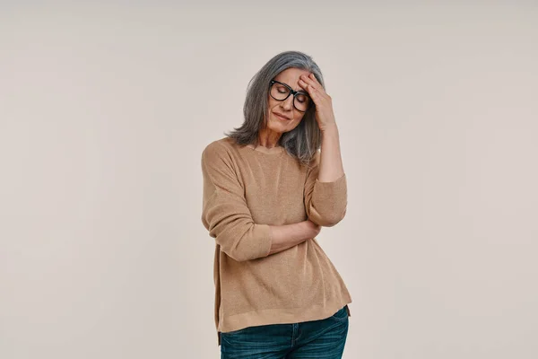 Frustrated mature woman suffering from headache and touching her forehead — Stock Photo, Image