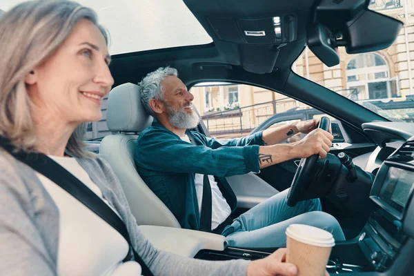 Actief senior paar genieten van autorit terwijl zitten op de voorstoelen van de auto — Stockfoto