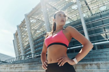 Spor giyim kuşağında el ele tutuşan kendine güvenen genç bir kadının bakış açısı.