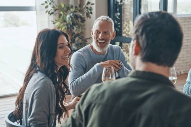 Mutlu bir aile yemeği yerken iletişim kuruyor ve gülümsüyor.