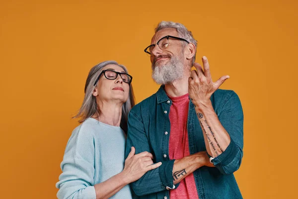 Playful senior couple in eyeglasses smiling and gesturing — Stock Photo, Image