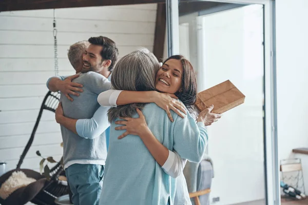 Padres mayores felices conociendo pareja joven dentro de la casa — Foto de Stock