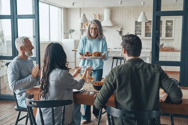 Moderna familia multi-generación sonriendo mientras cenan juntos — Foto de Stock