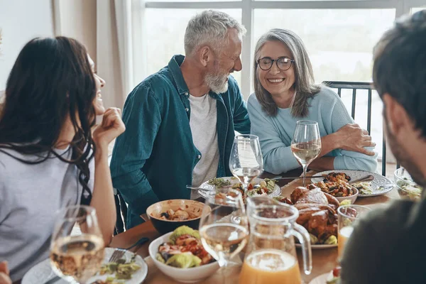 Mutlu çoklu nesil aile yemeği yerken iletişim kuruyor ve gülümsüyor. — Stok fotoğraf