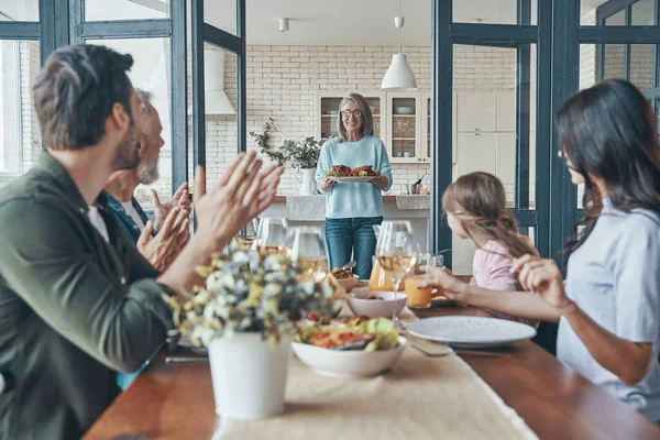 Feliz familia multi-generación comunicándose y sonriendo mientras cenan juntos — Foto de Stock